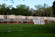 NT evacuees from flooded remote communities housed behind fences, likened to 'prison camp'