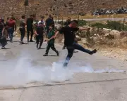Palestinian kicks teargas cylinder as Israeli forces demolish home in Hebron
