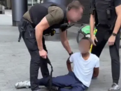 Man comforts black boy handcuffed by police in East London over playfighting